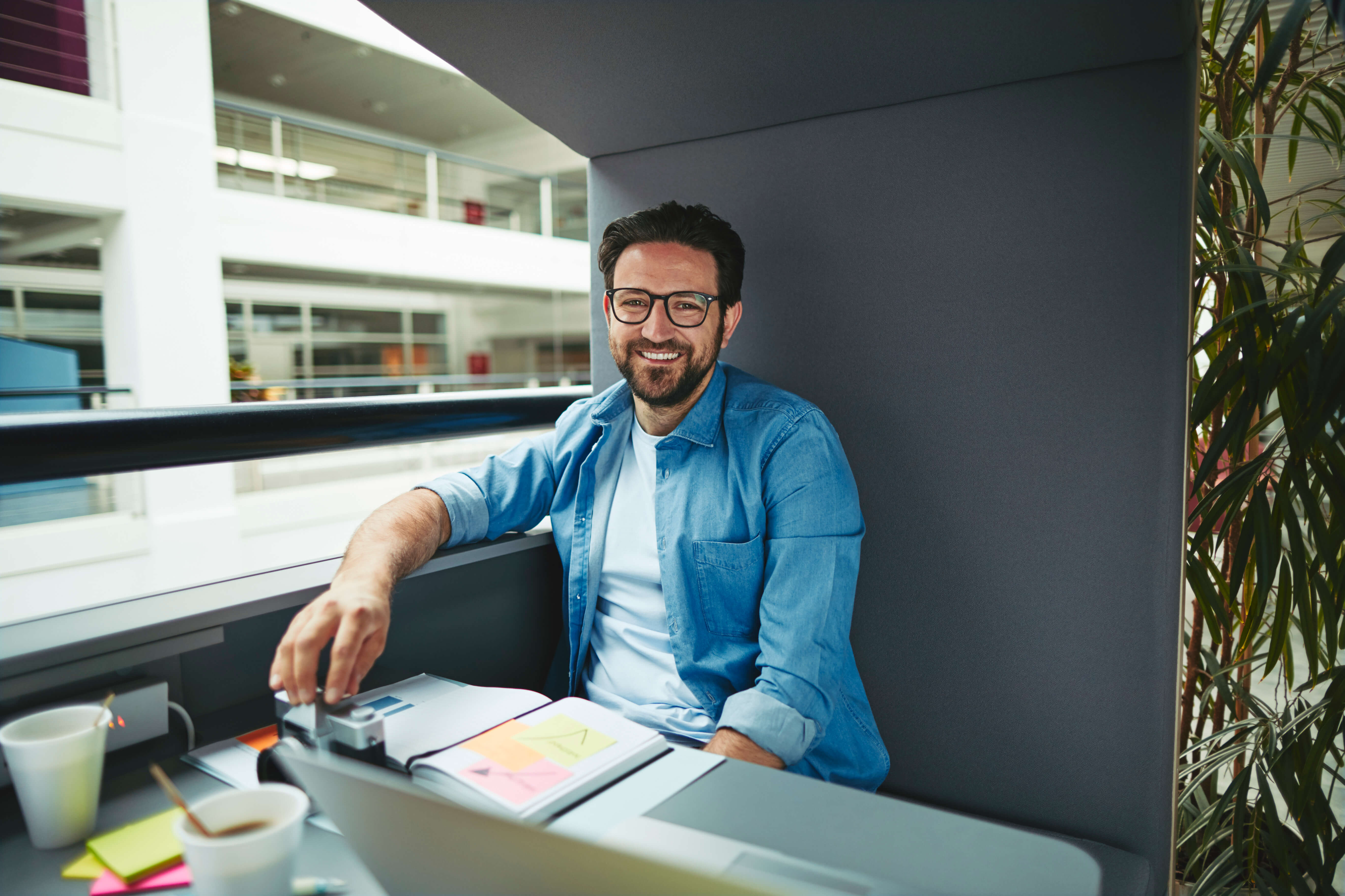 Smiling man sitting at his coworking desk