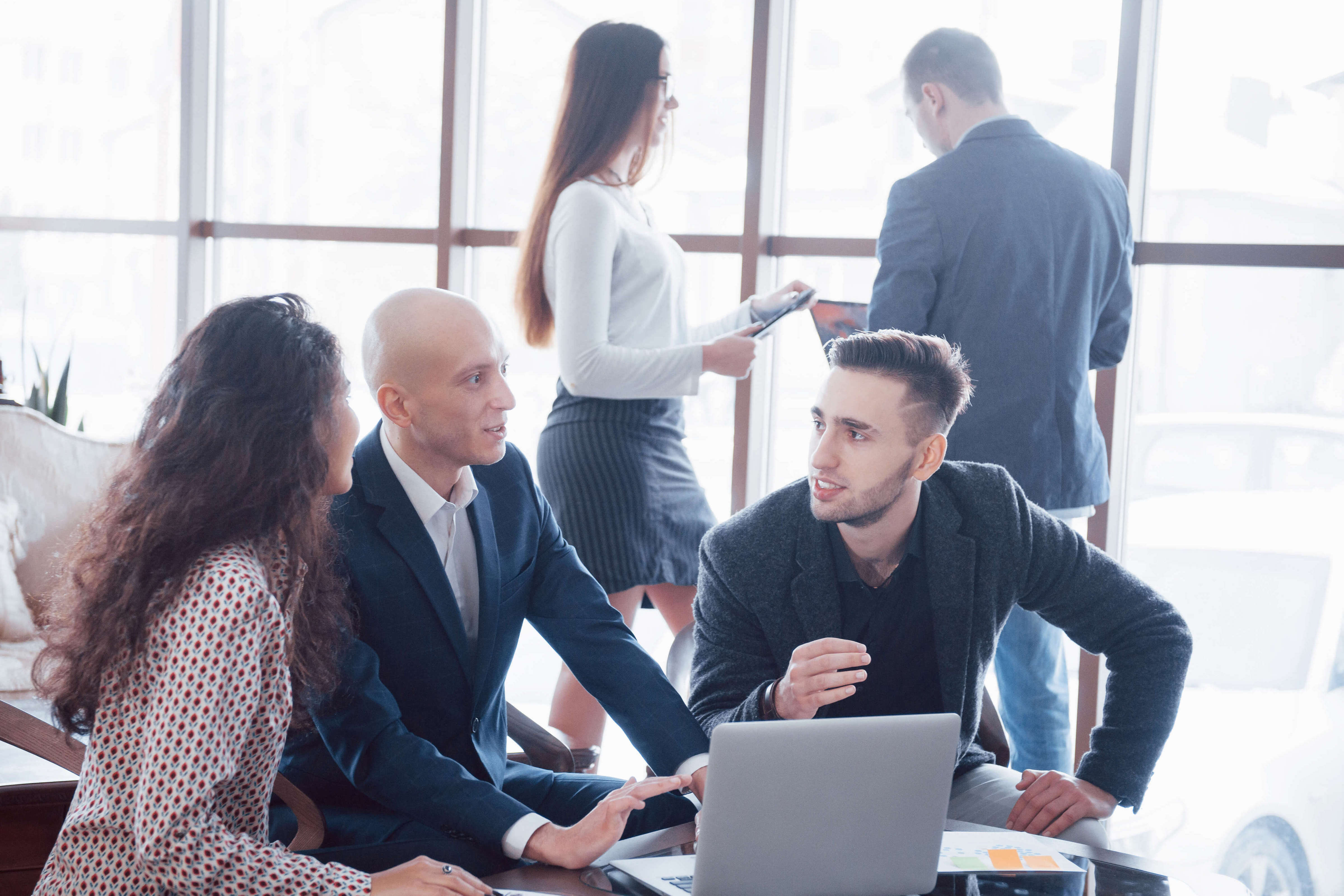 Jeune équipe de collaborateurs qui font une grande discussion d'affaires dans un bureau de coworking moderne