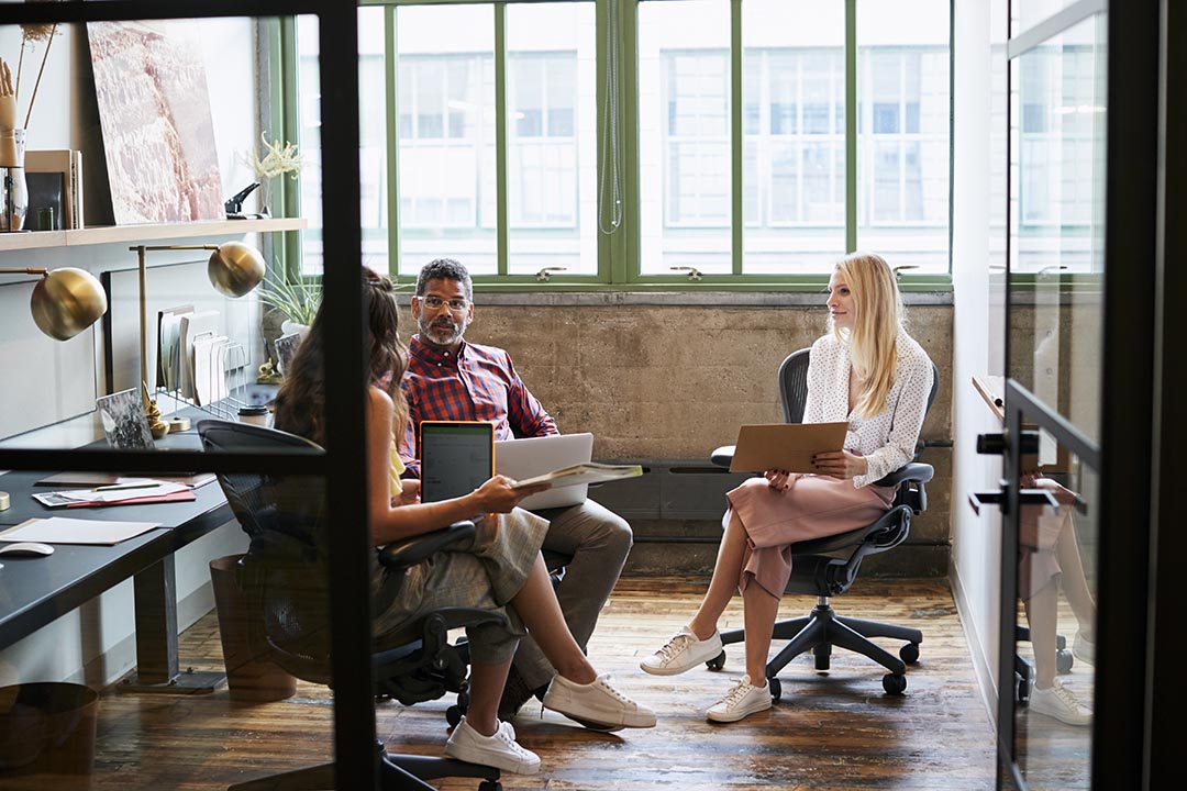 A team of digital marketing specialists in the middle of a meeting in a coworking space