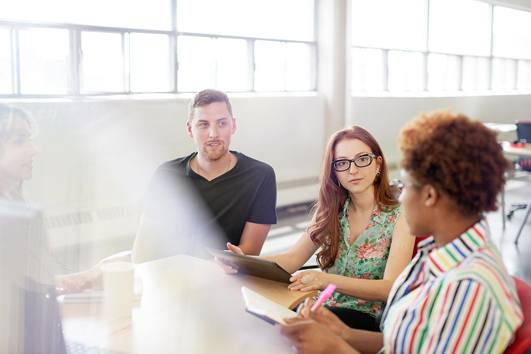 Four coworkers discussing at their local Hive Montréal coworking space.